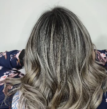 Mechas acinzentadas em cabelo médio ondulado